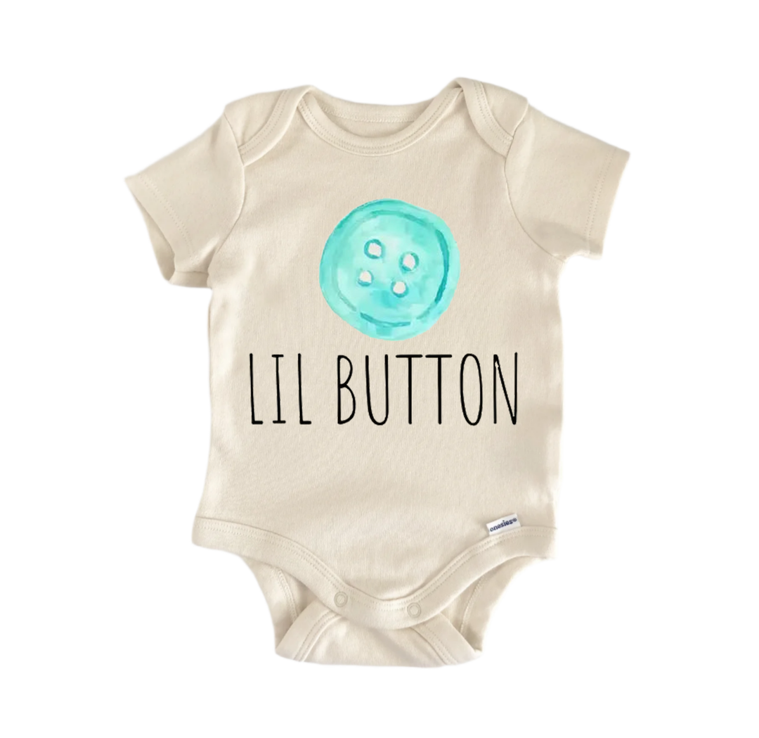 A beige baby onesie with a teal button printed on it and the text "LIL BUTTON" printed below it.
