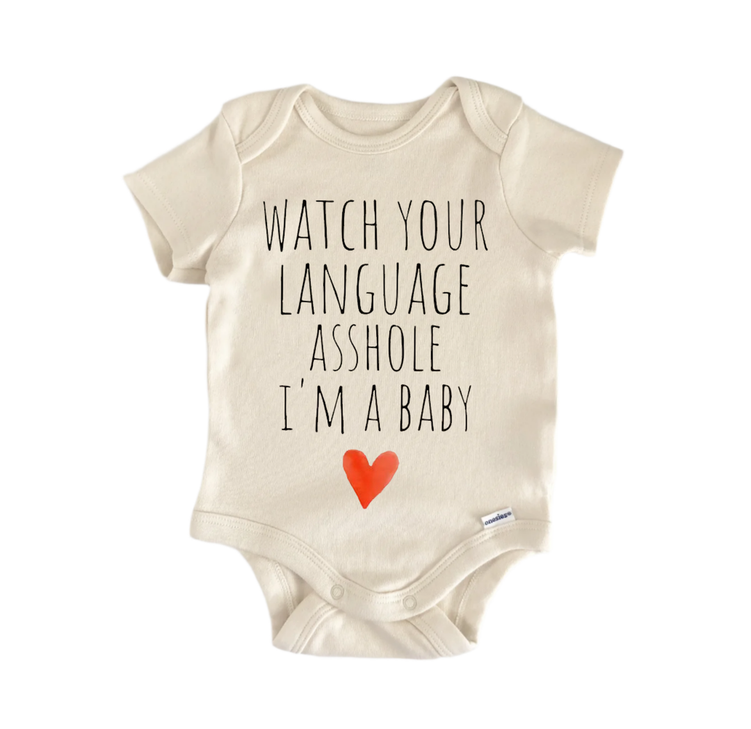 A beige baby onesie with the text "WATCH YOUR LANGUAGE ASSHOLVE I'M A BABY" printed on it, along with a small red heart symbol.