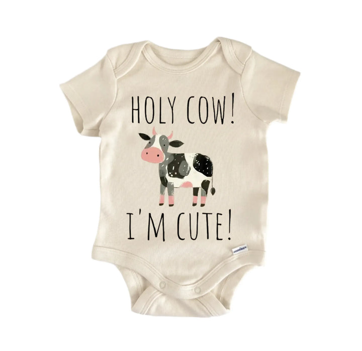 A beige baby onesie with a cartoon cow and the text "HOLY COW! I&
