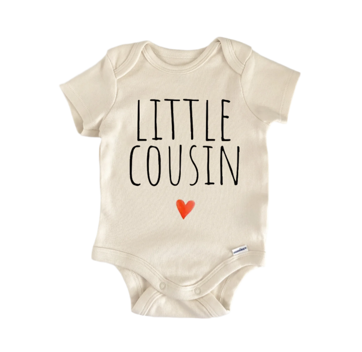 A beige baby onesie with the text "LITTLE COUSIN" printed on it, along with a small red heart symbol.