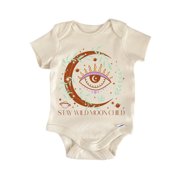 A beige baby onesie with a moon and eye design, along with the text "STAY WILD MOON CHILD" printed on it.
