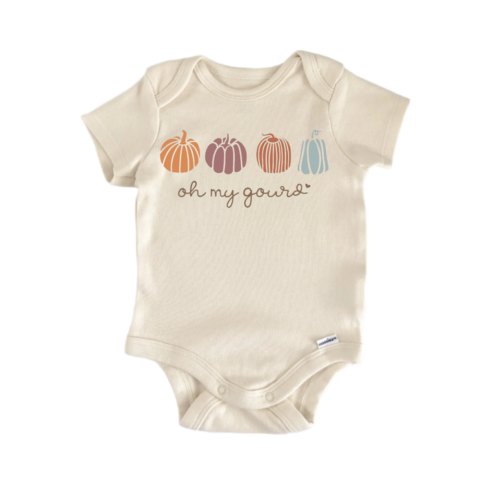 A beige baby onesie with a graphic design featuring four pumpkins in different colors arranged in a row, with the phrase "oh my gourd" written below them.