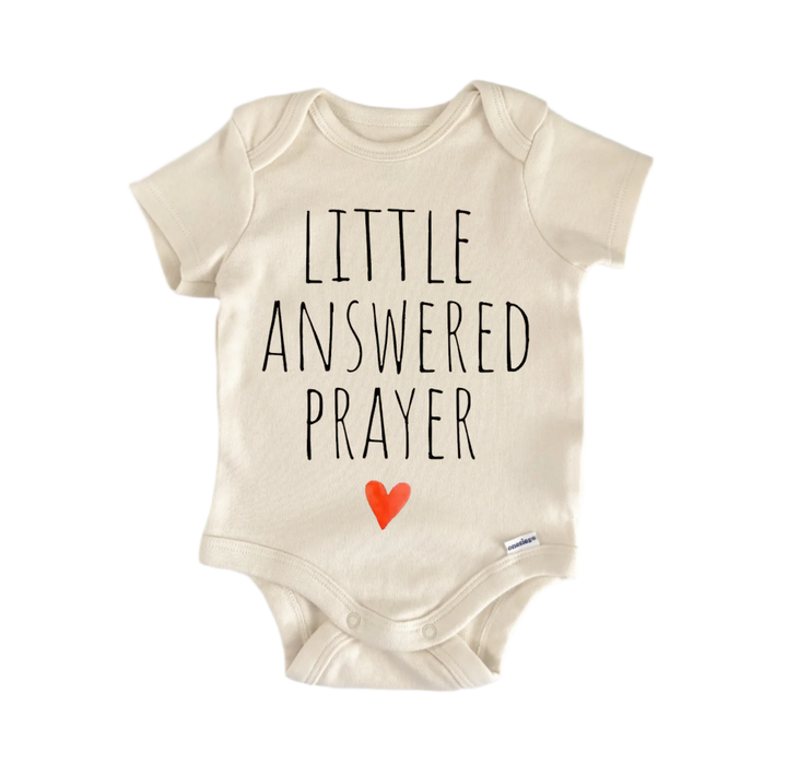 A beige baby onesie with the text "LITTLE ANSWERED PRAYER" printed on it.