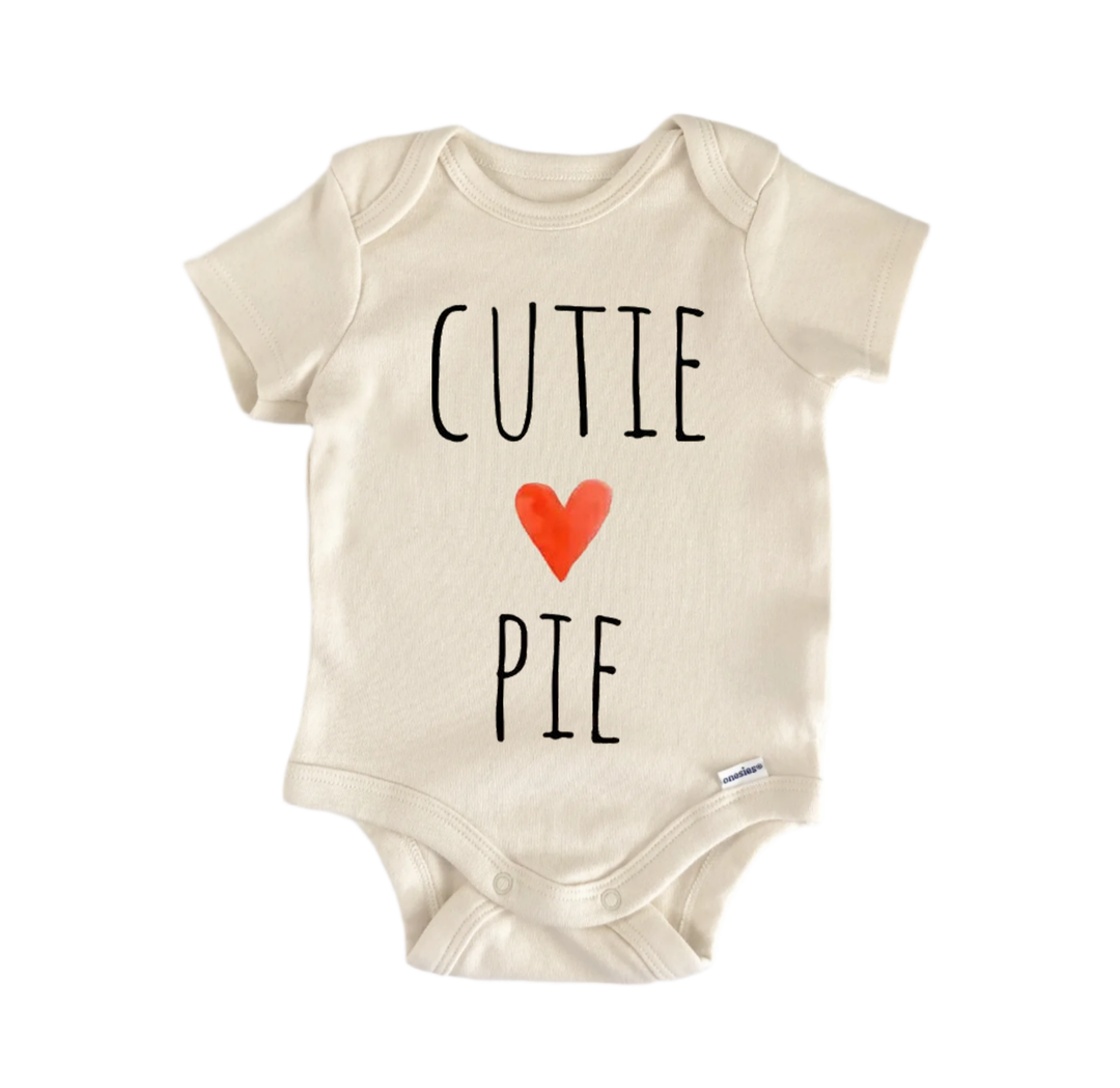 A beige baby onesie with the text "CUTIE PIE" printed on it.