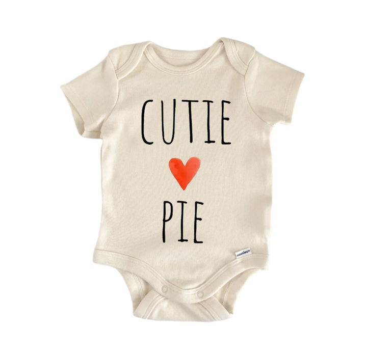 A beige baby onesie with the text "CUTIE PIE" printed on it.
