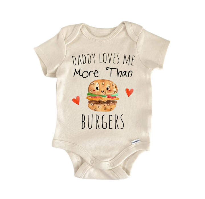 A baby onesie with a printed message that reads "DADMY LOVES ME MORE THAN BURGERS" along with an illustration of a hamburger.