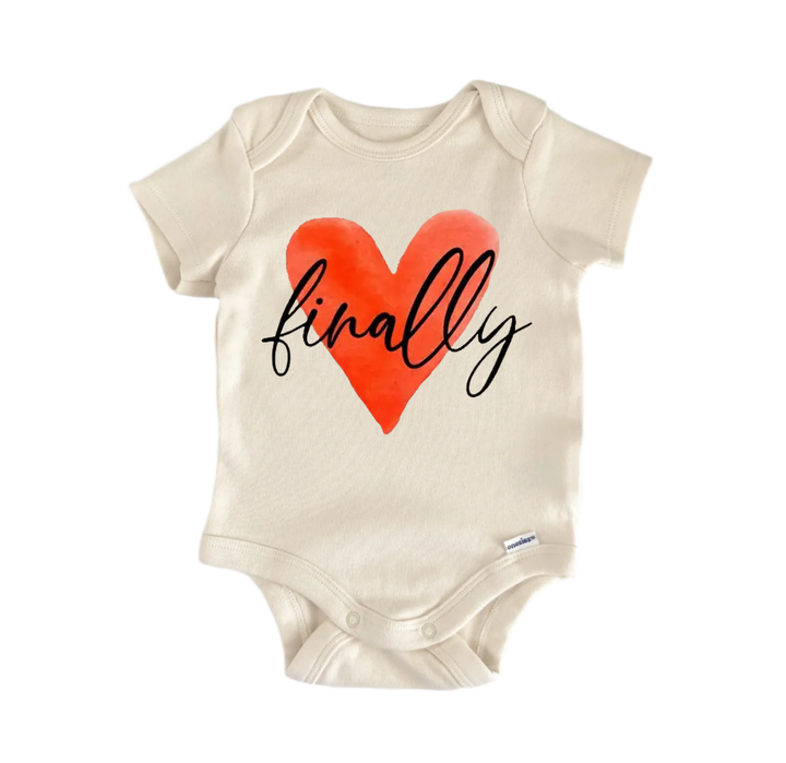 A beige baby onesie with a red heart and the word "finALLY" printed on it.