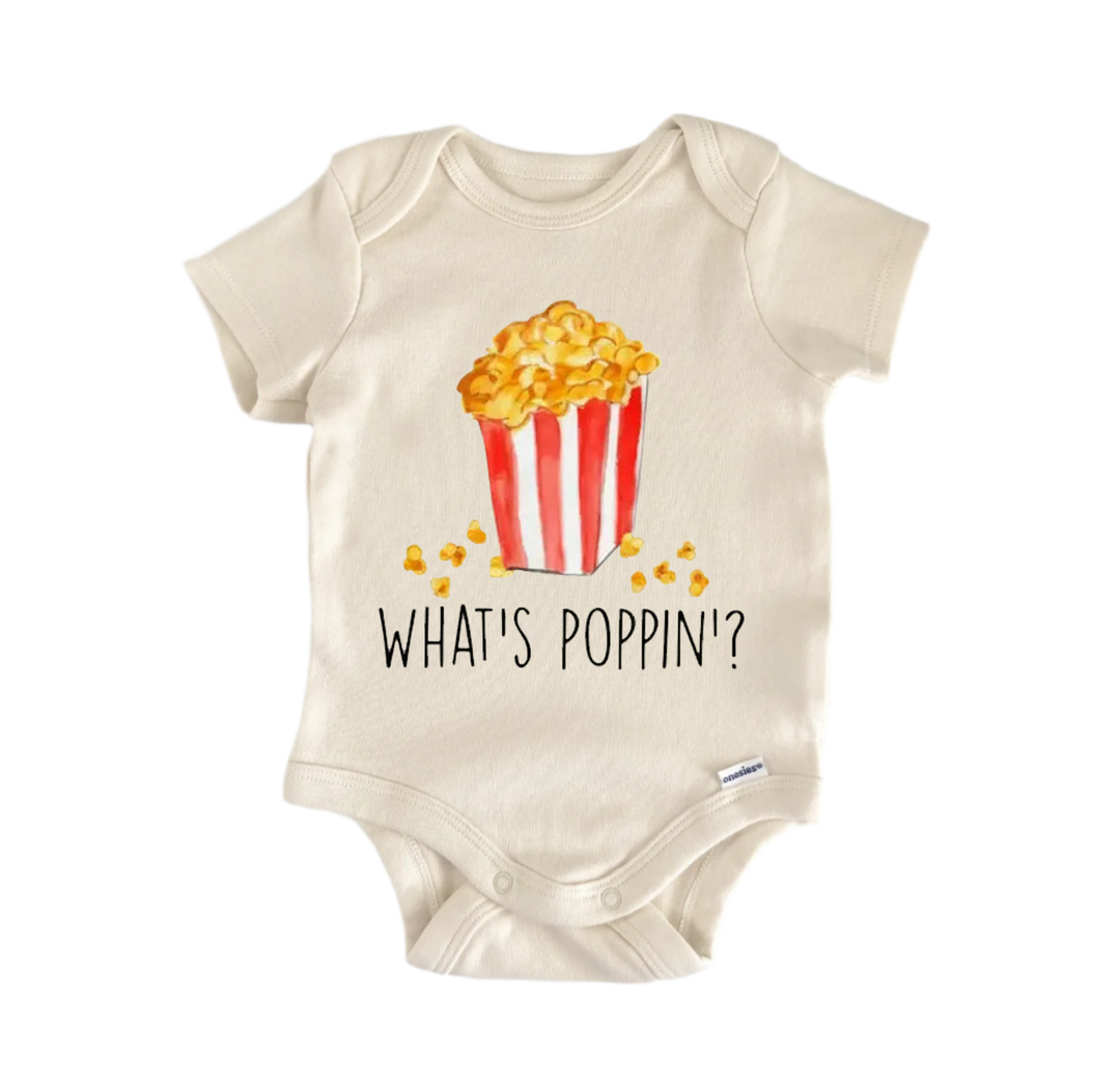 A baby onesie with a printed design of a popcorn bucket and the text "WHAT'S POPPIN'?"