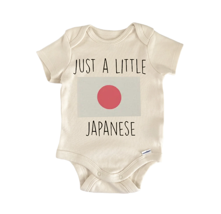 A beige baby onesie with the text "JUST A LITTLE JAPANESE" printed on it, along with a small red circle representing the Japanese flag.