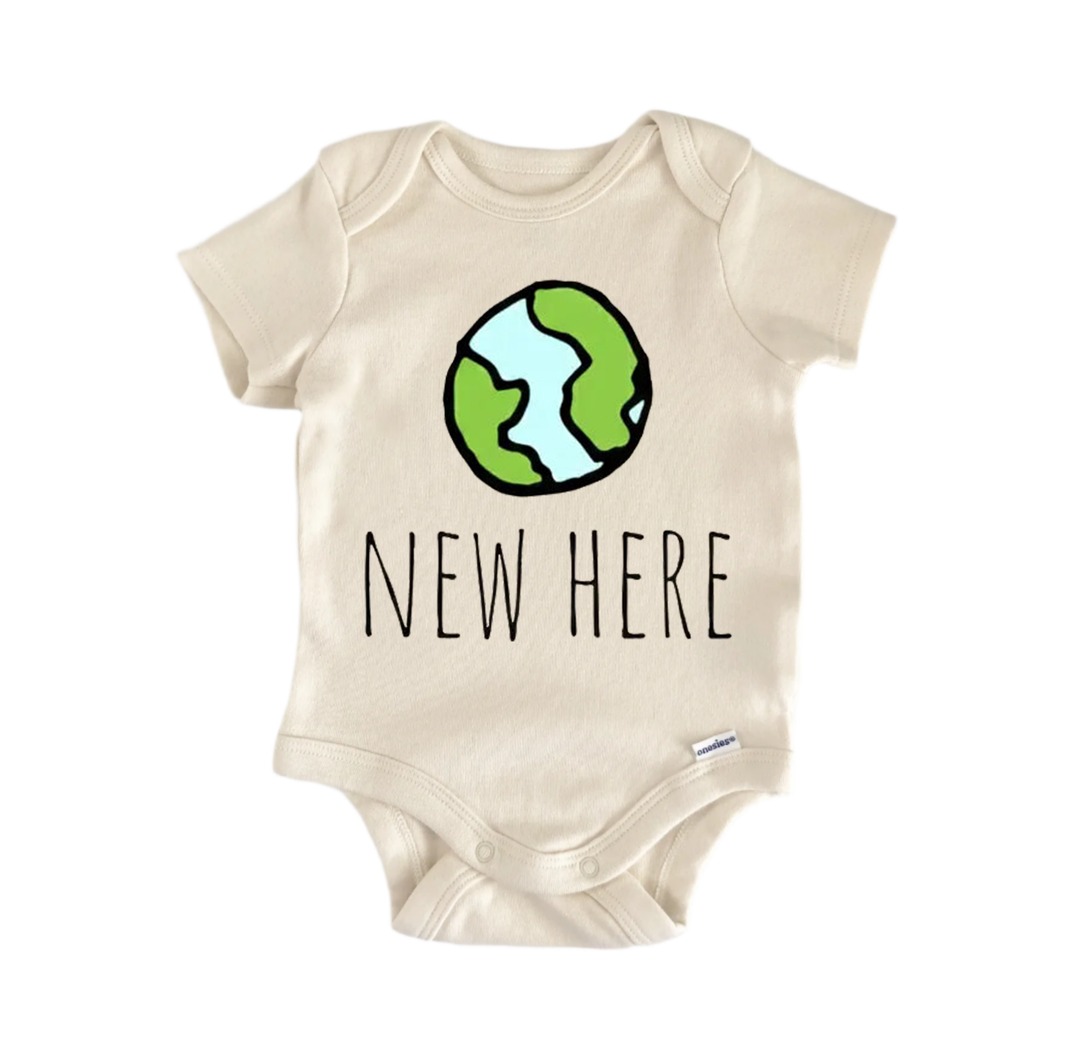 A beige baby onesie with a green and blue illustration of the Earth and the text "NEW HERE" printed on it.