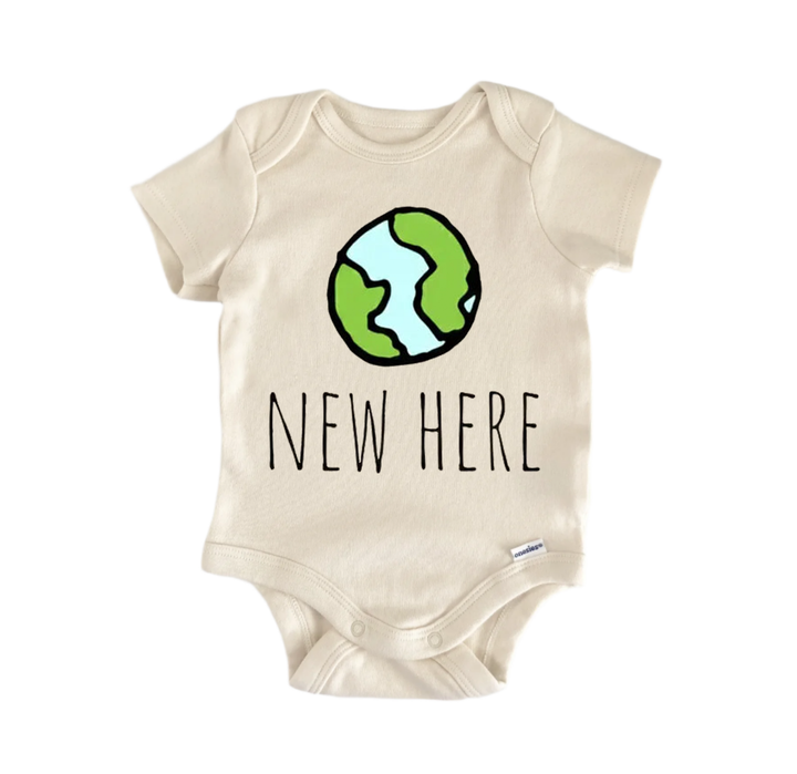 A beige baby onesie with a green and blue illustration of the Earth and the text "NEW HERE" printed on it.