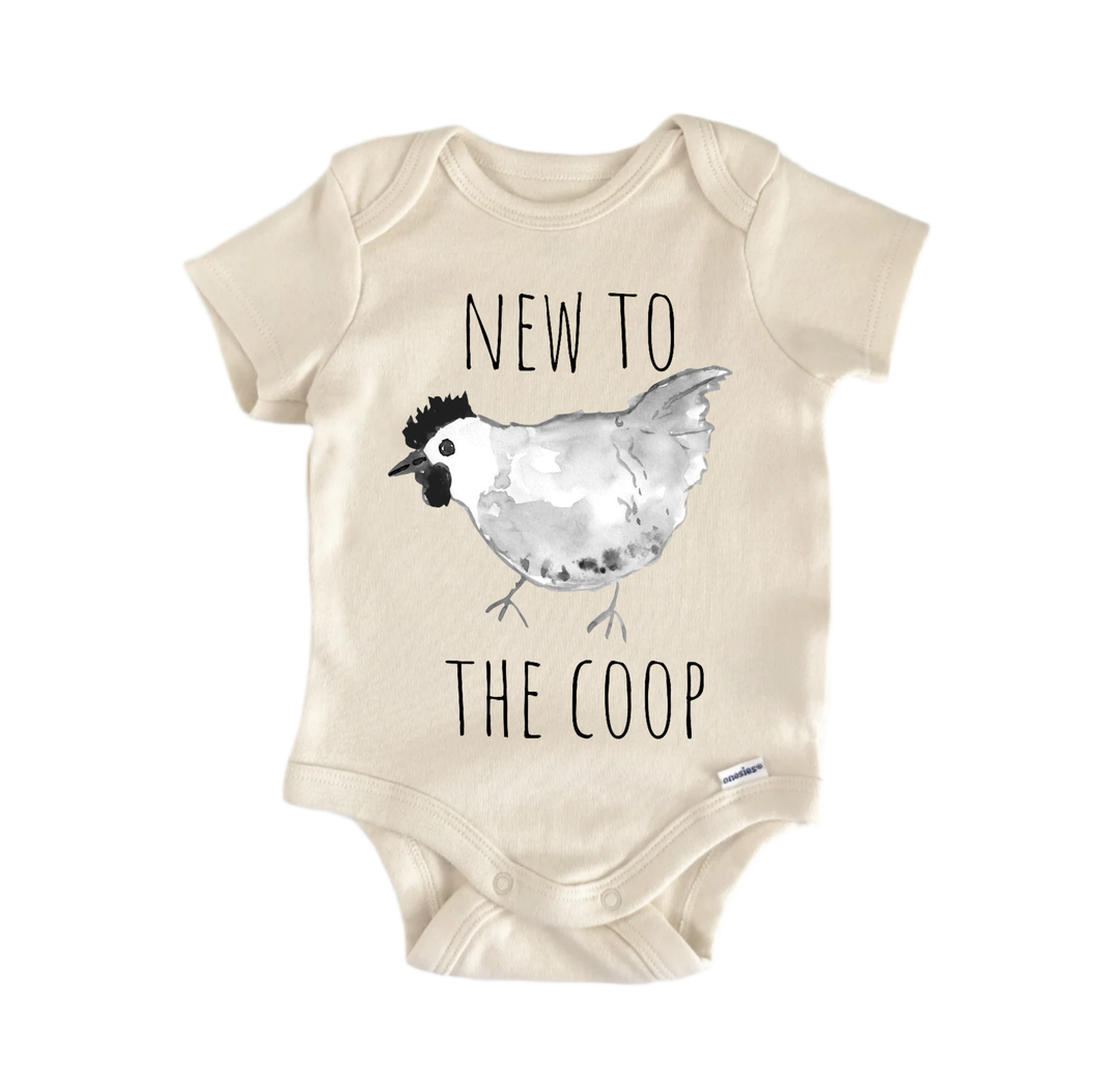 A beige baby onesie with a black and white illustration of a chicken and the text "NEW TO THE COOP" printed on it.