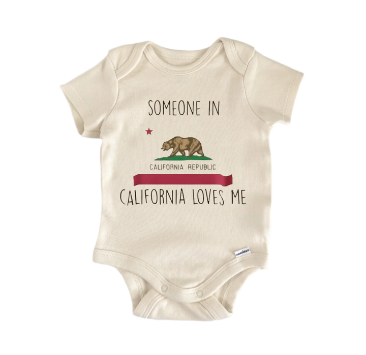 A beige baby onesie with a California state flag design and text that reads "California loves me".