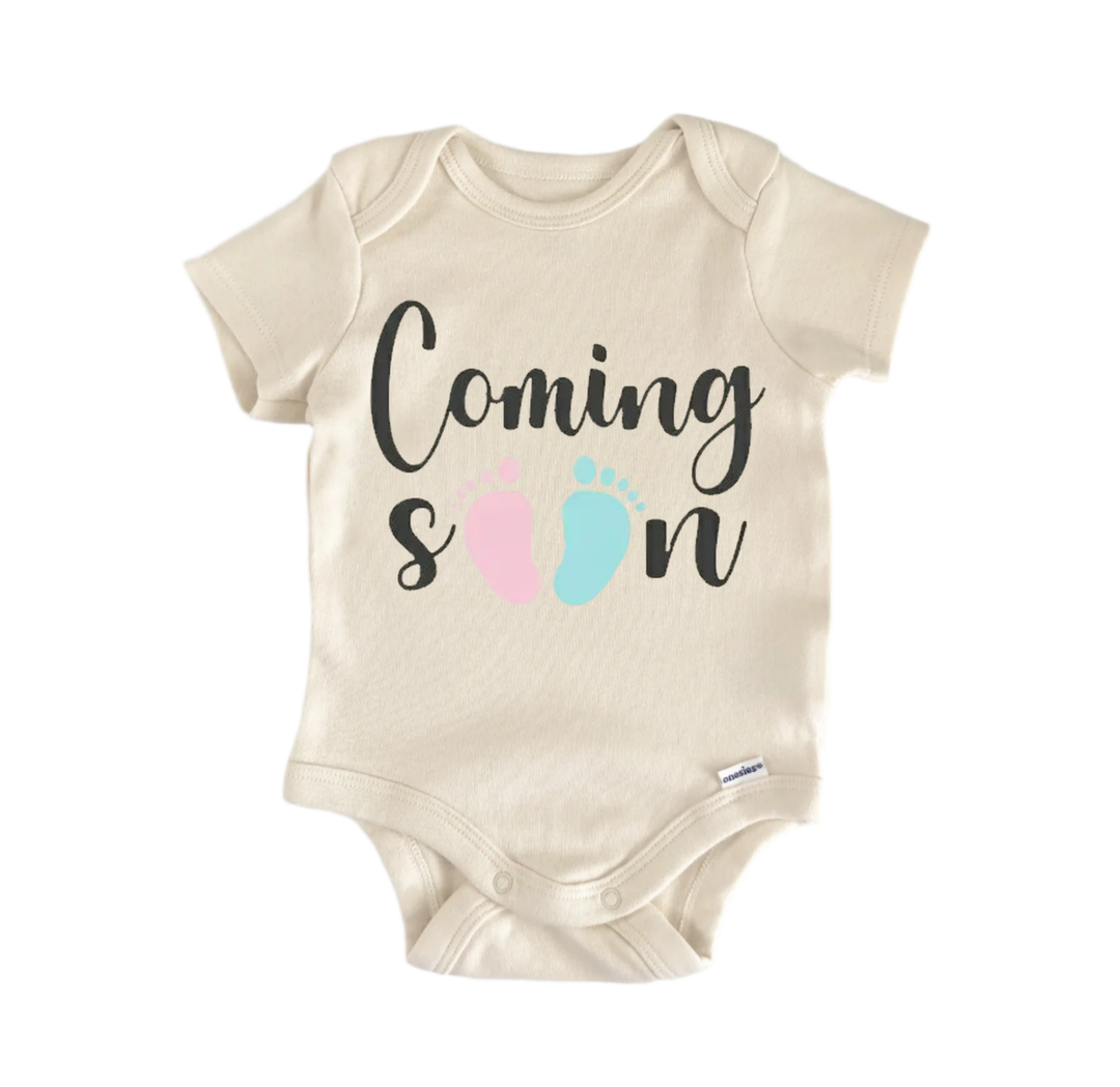 A beige baby onesie with the text "Coming soon" printed on it.