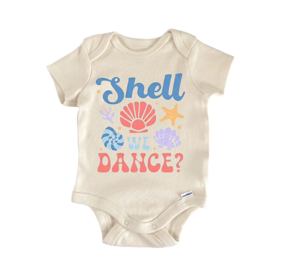 A beige baby onesie with a colorful graphic design featuring a shell, starfish, and other sea-themed elements, along with the text "Shell we dance?".