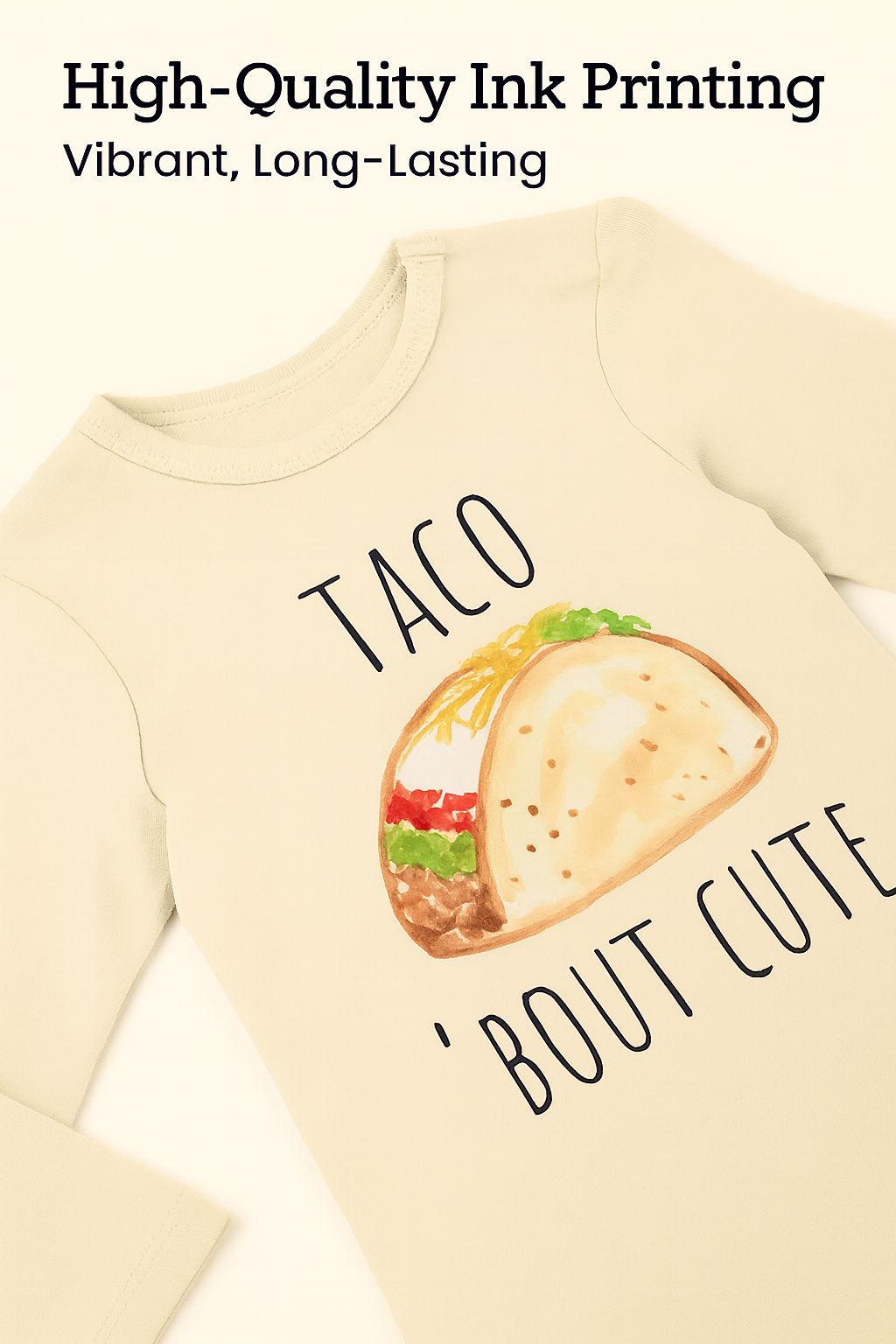 A beige long-sleeved t-shirt with a printed design of a taco and the text "TACO 'BOUT CUTE" printed on it.
