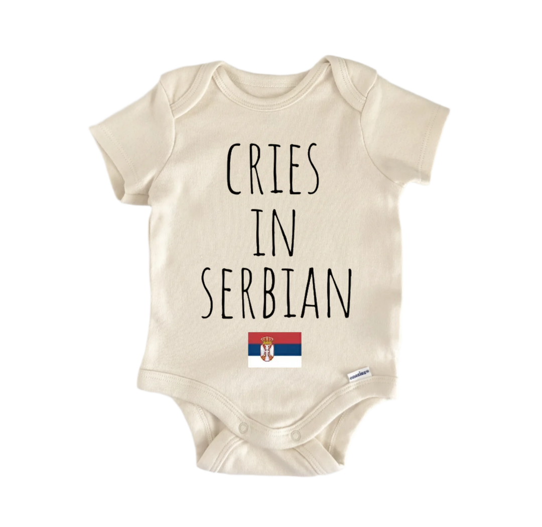 A beige baby onesie with the text "CRIES IN SERBIAN" printed on it.