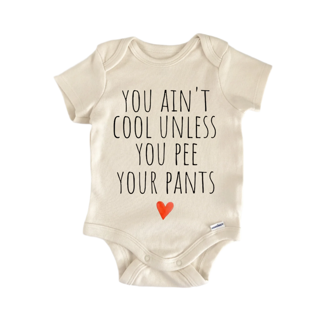 A beige baby onesie with the text "YOU AIN'T COOL UNLESS YOU PEE YOUR PANTS" printed on it.