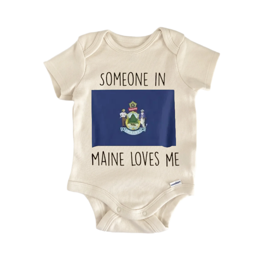 A beige baby onesie with the text "SOMEONE IN MAINE LOVES ME" printed on it, along with a graphic of the state flag of Maine.
