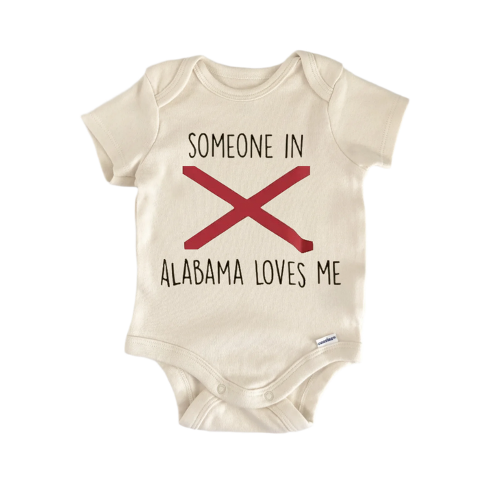 A beige baby onesie with the text "SOMEONE IN ALABAMA LOVES ME" printed on it.