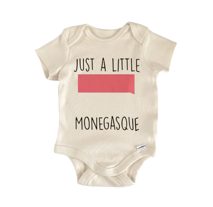 A beige baby onesie with the text "JUST A LITTLE MONEGASQUE" printed on it.