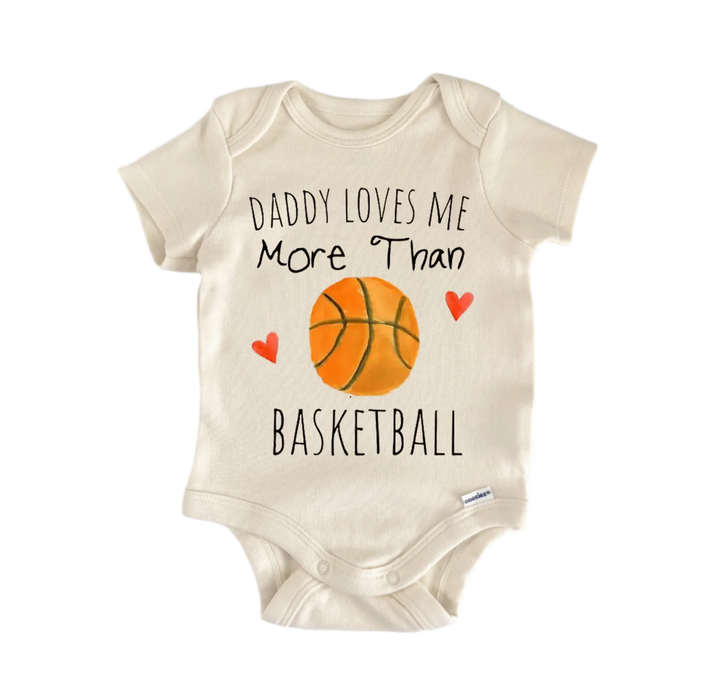 A beige baby onesie with the text "DADDAUGHTER LOVES ME MORE THAN BASKETBALL" printed on it, along with an illustration of a basketball.
