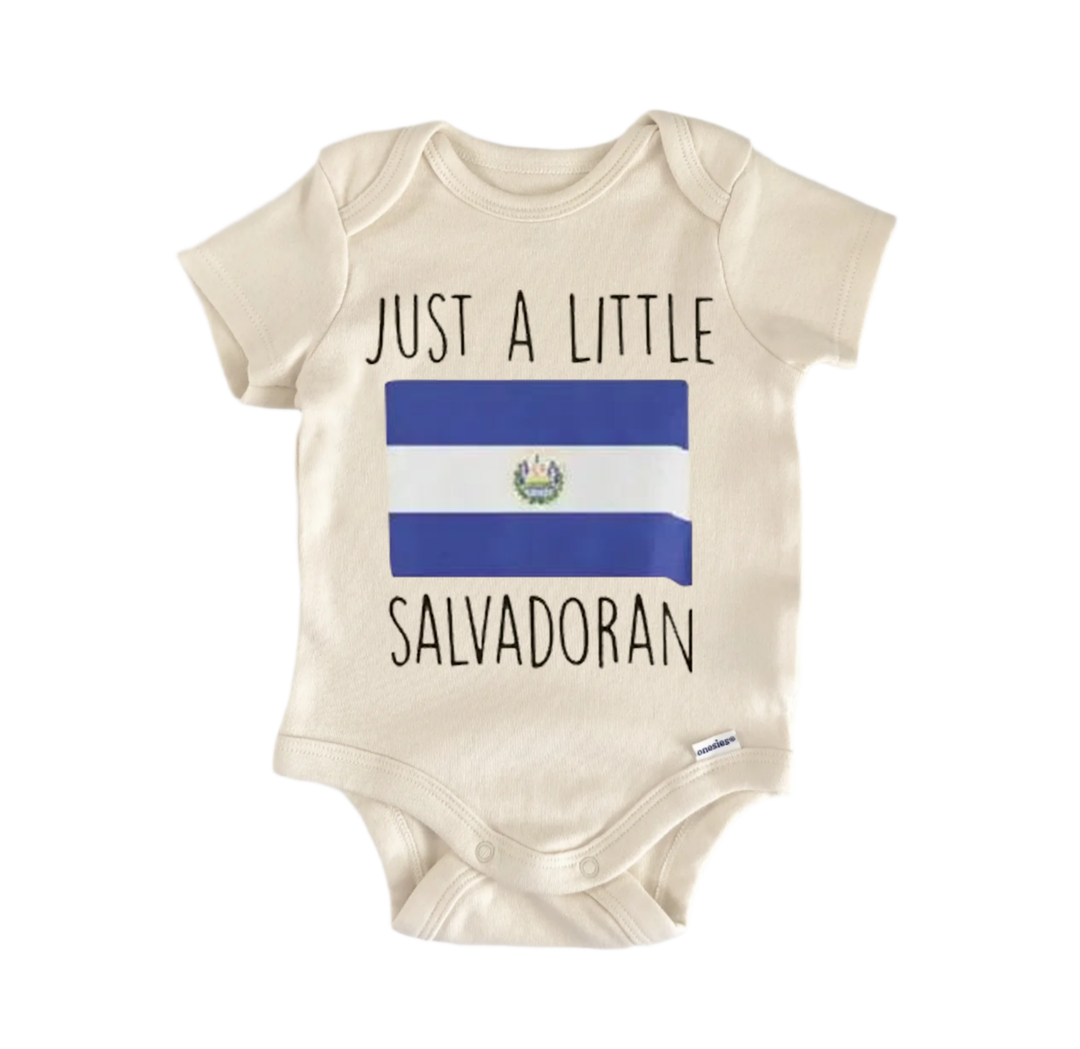 A beige baby onesie with the text "JUST A LITTLE SALVADORAN" printed on it, along with the flag of El Salvador.