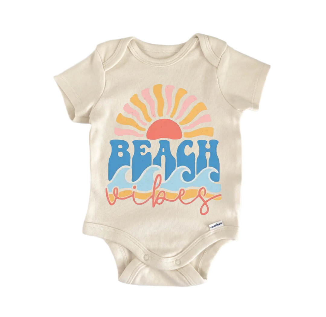 A beige baby onesie with a colorful graphic design featuring a sun and waves, along with the text "BEACH vibes" printed on it.
