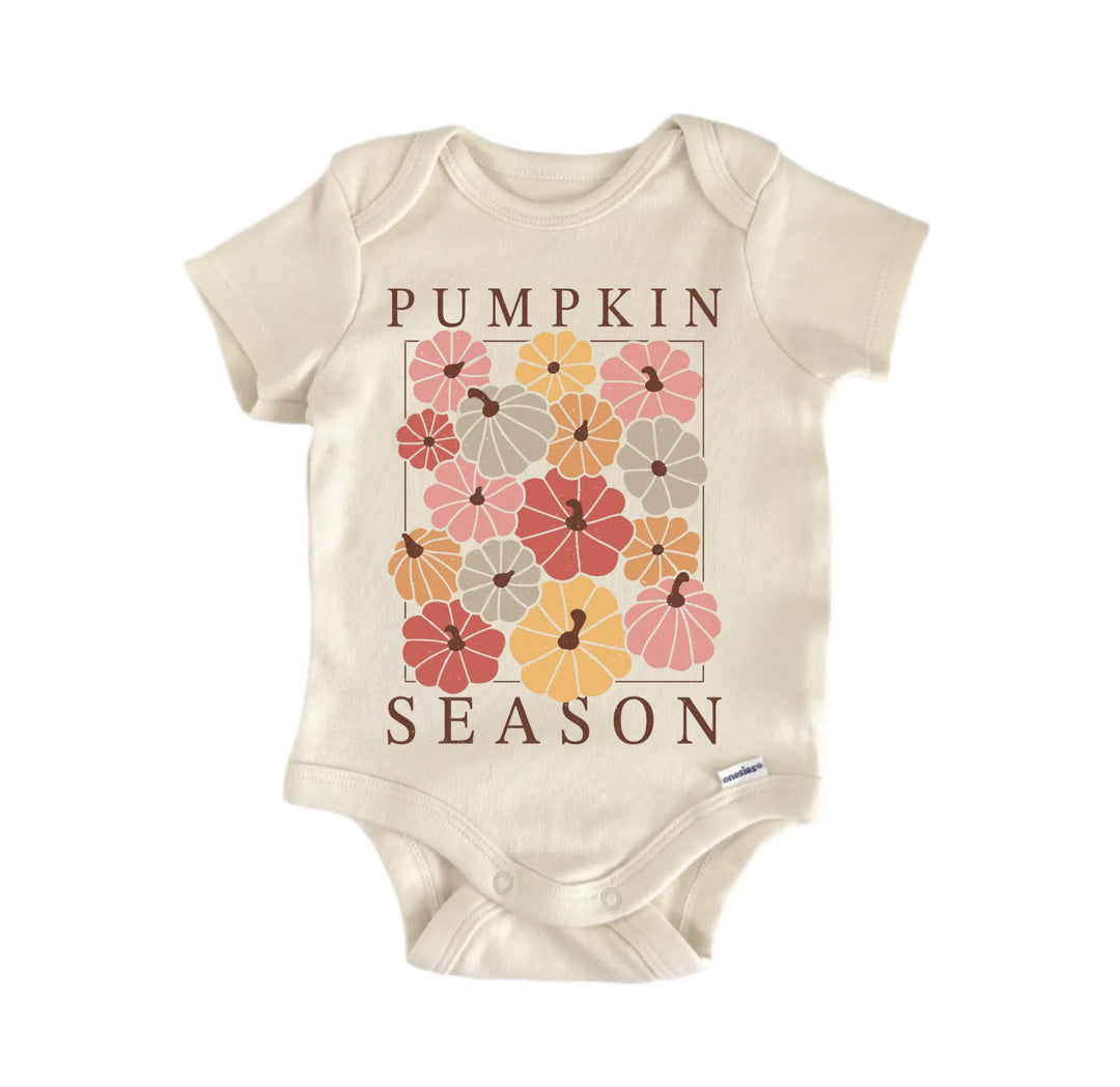 A beige baby onesie with a graphic design of pumpkins and the text "Pumpkin Season" printed on it.