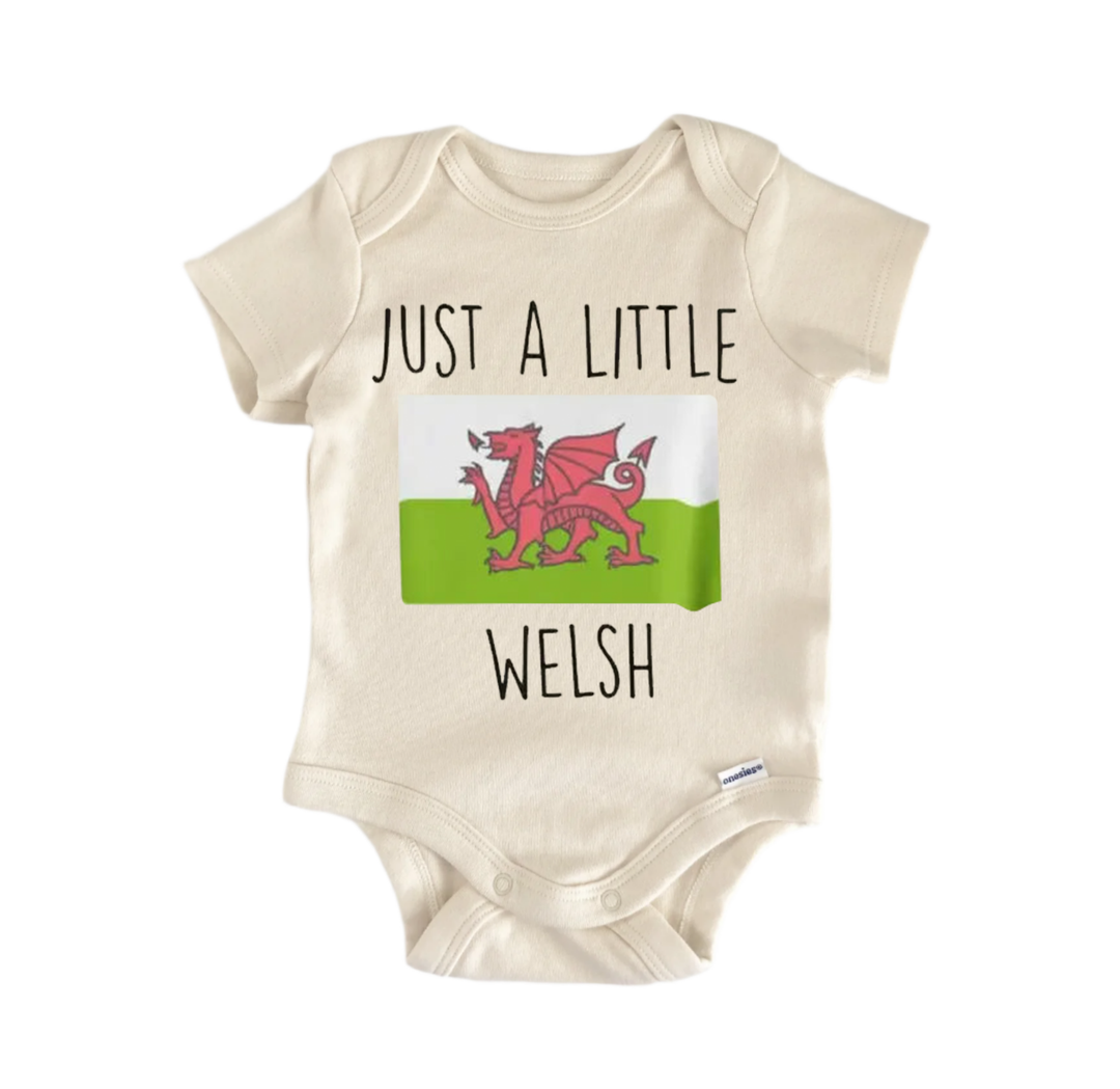 A beige baby onesie with a graphic of a red dragon and the text "Just a little Welsh" printed on it.